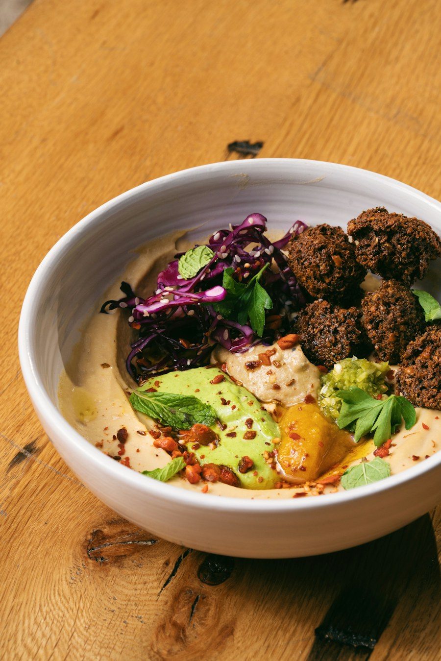 Falafel in a bowl with hummus and salad